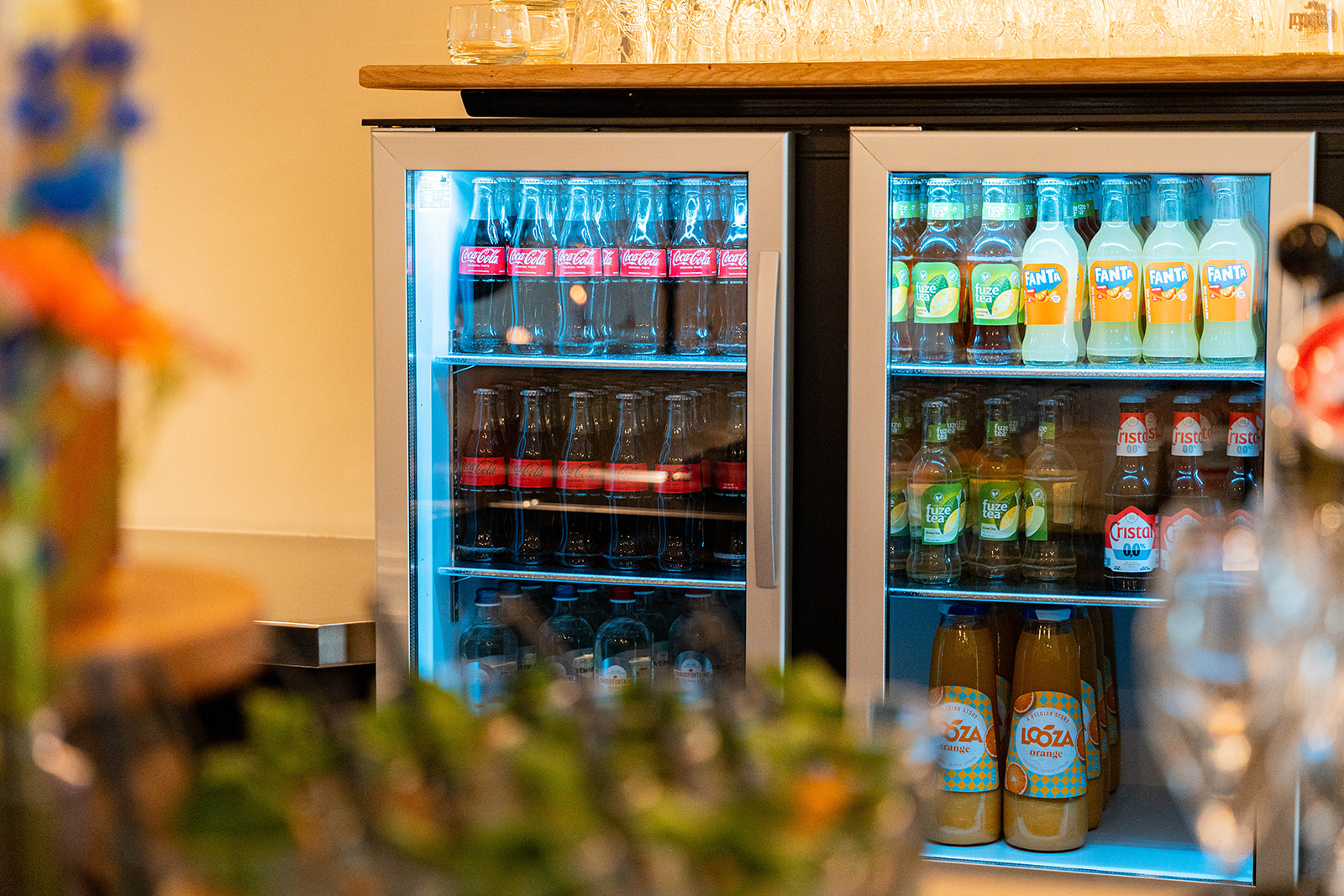 Verlichte koeling achter de bar met frisdranken en sappen