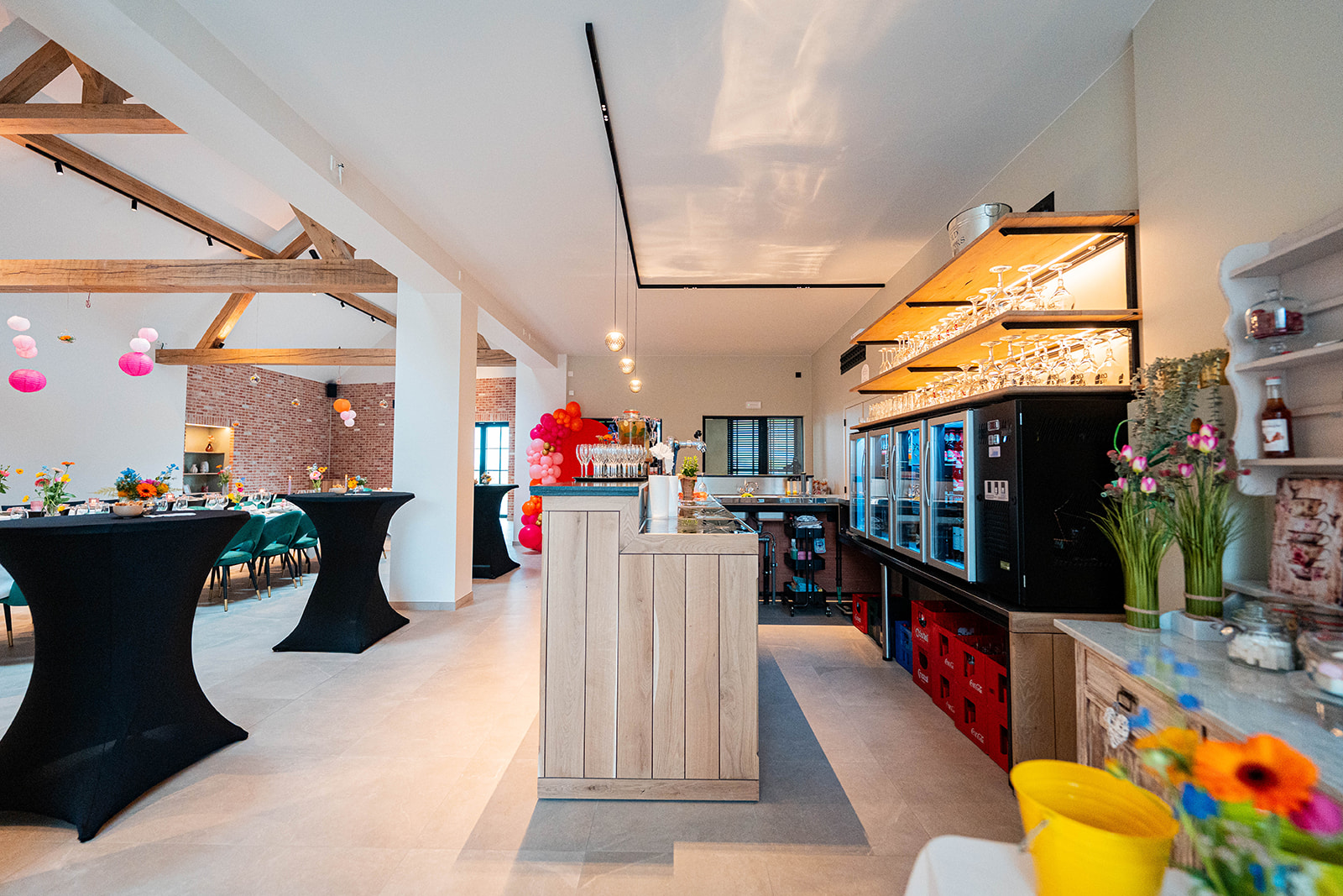 Bar met zicht op de feestzaal en statafels