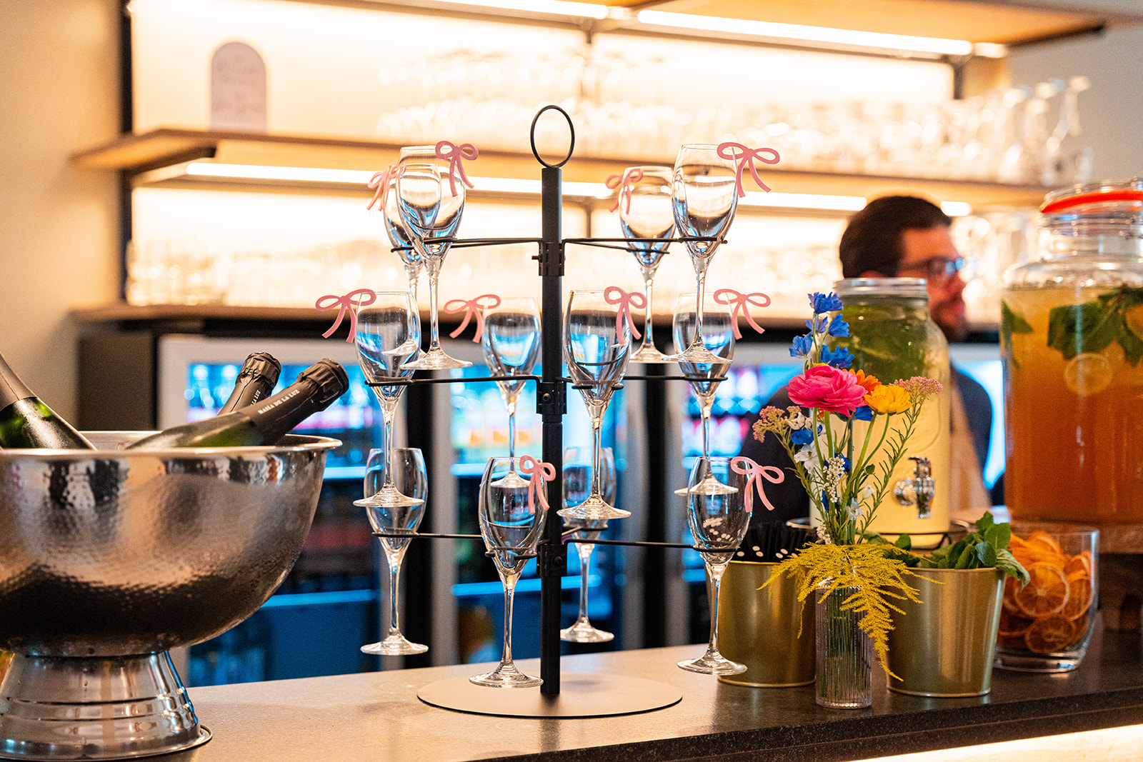 Champagneglazen met roze strikjes en cava op ijs aan de bar