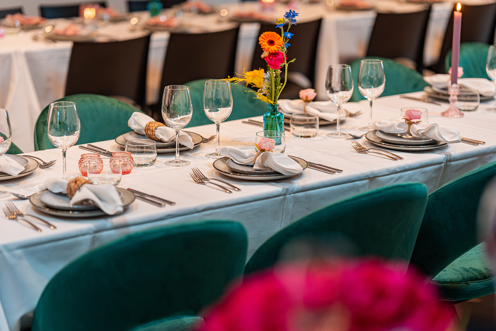 Sfeervol gedekte feesttafel met smaragdgroene velvet stoelen en bloemen