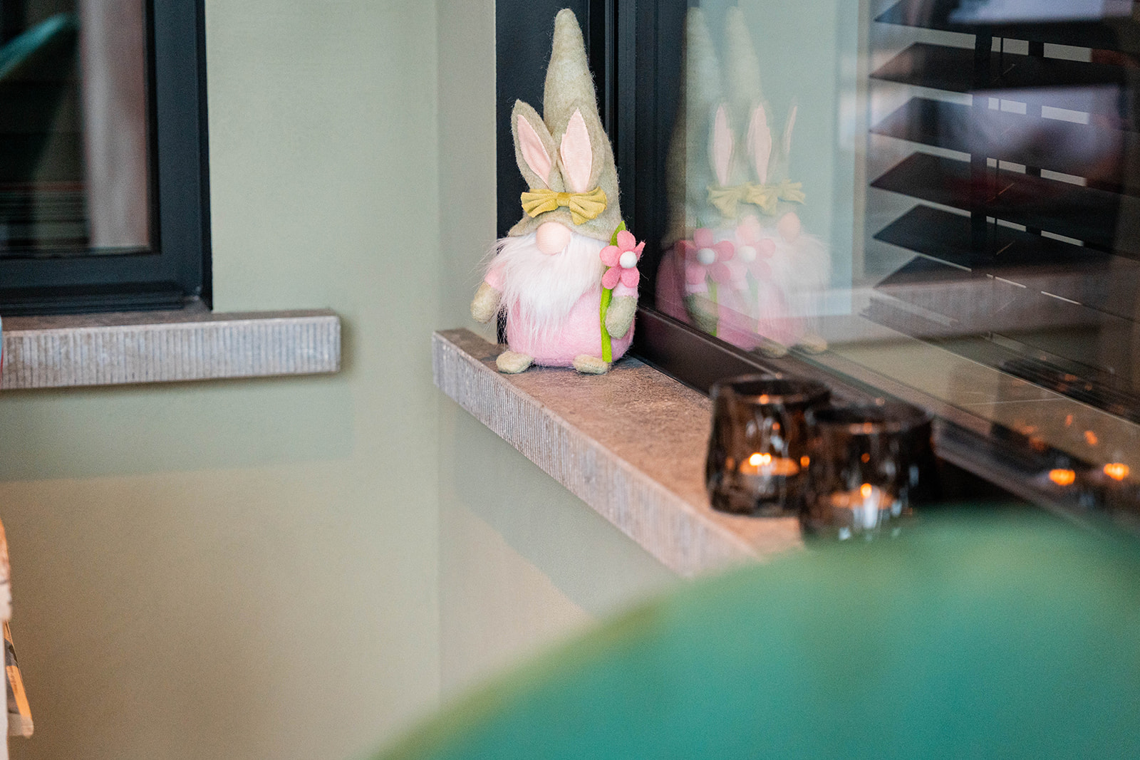 Lente decoratie met paaskabouter op vensterbank in saliegroene zaal