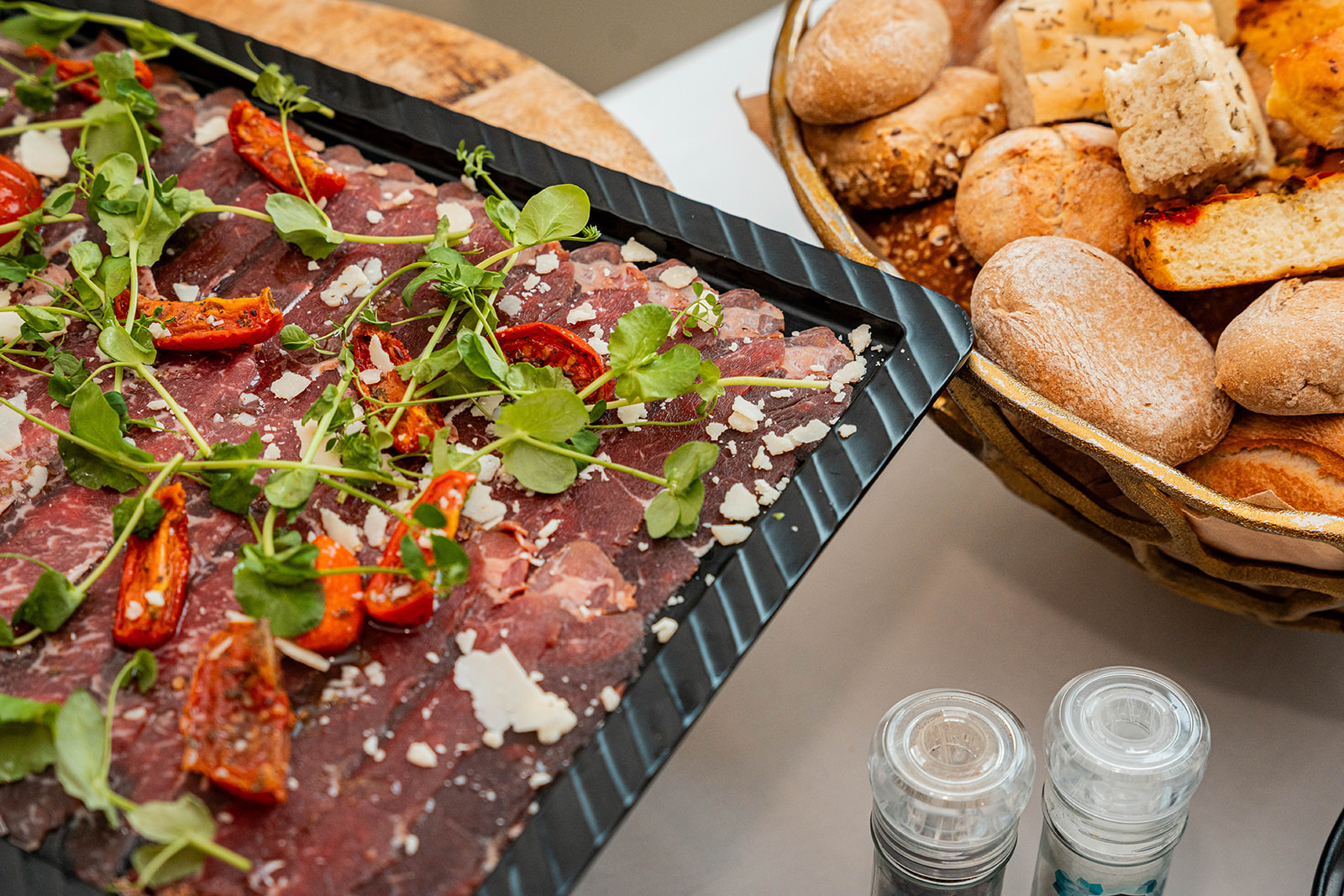 Carpaccio met gedroogde tomaten, parmezaan en broodmandje op buffet