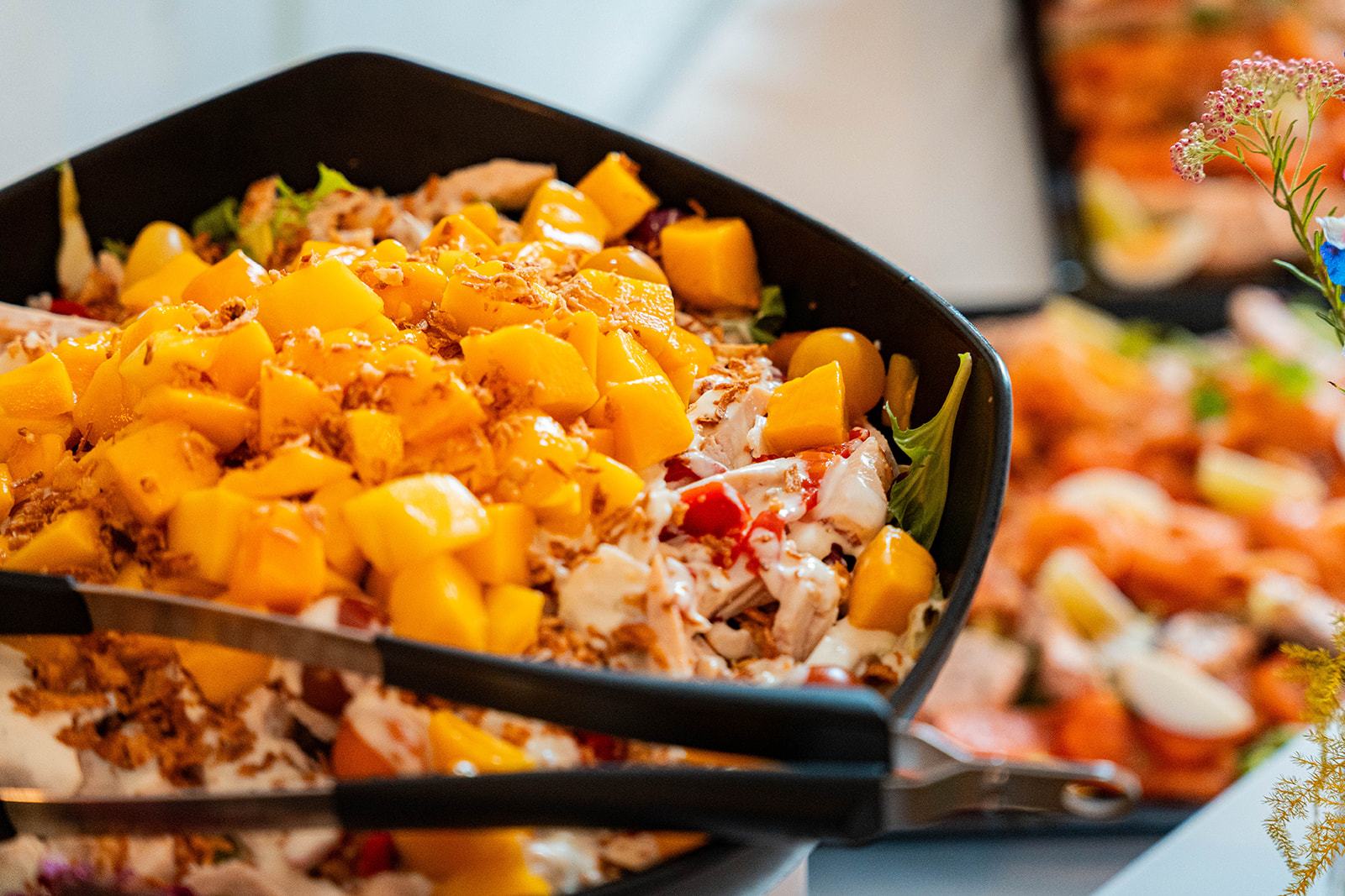 Frisse salade met kip, mango en gebakken uitjes op buffet
