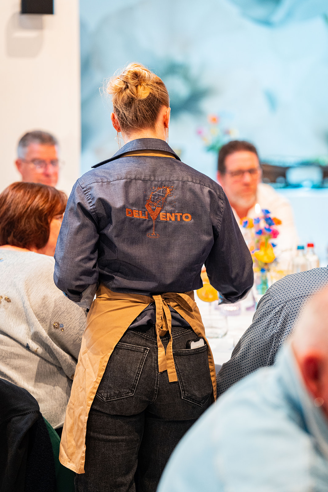 Delivento medewerker in gepersonaliseerd hemd met logo aan tafel