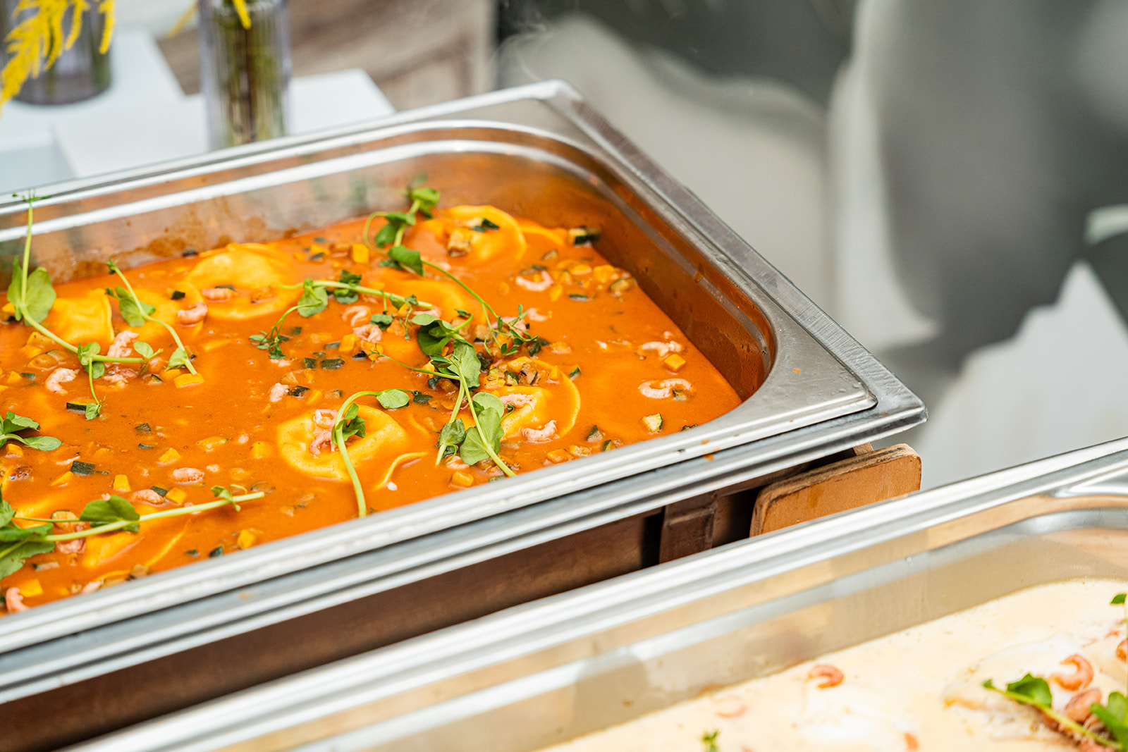 Romige tomatenbisque met ravioli en grijze garnalen in chafing dish