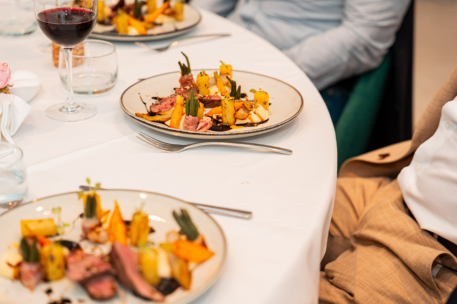Verfijnd hoofdgerecht met eendenfilet en groenten op gedekte feesttafel