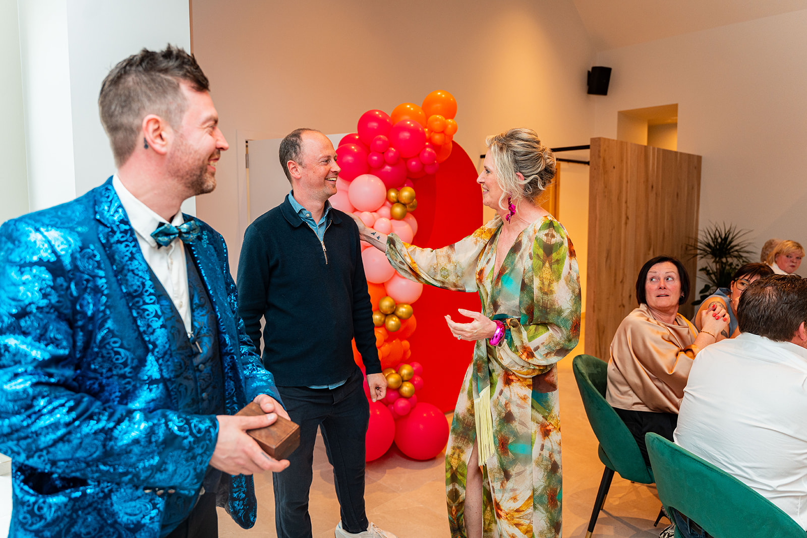 Goochelaar verrast gasten naast feestelijke ballonnenboog in de zaal