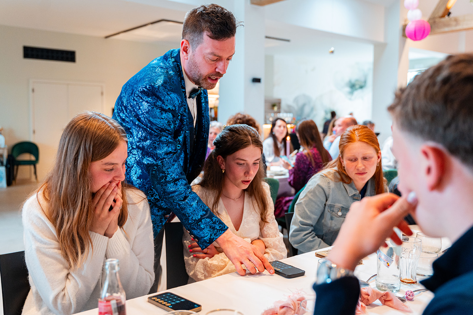 Goochelaar verrast jonge gasten met smartphone-truc aan tafel