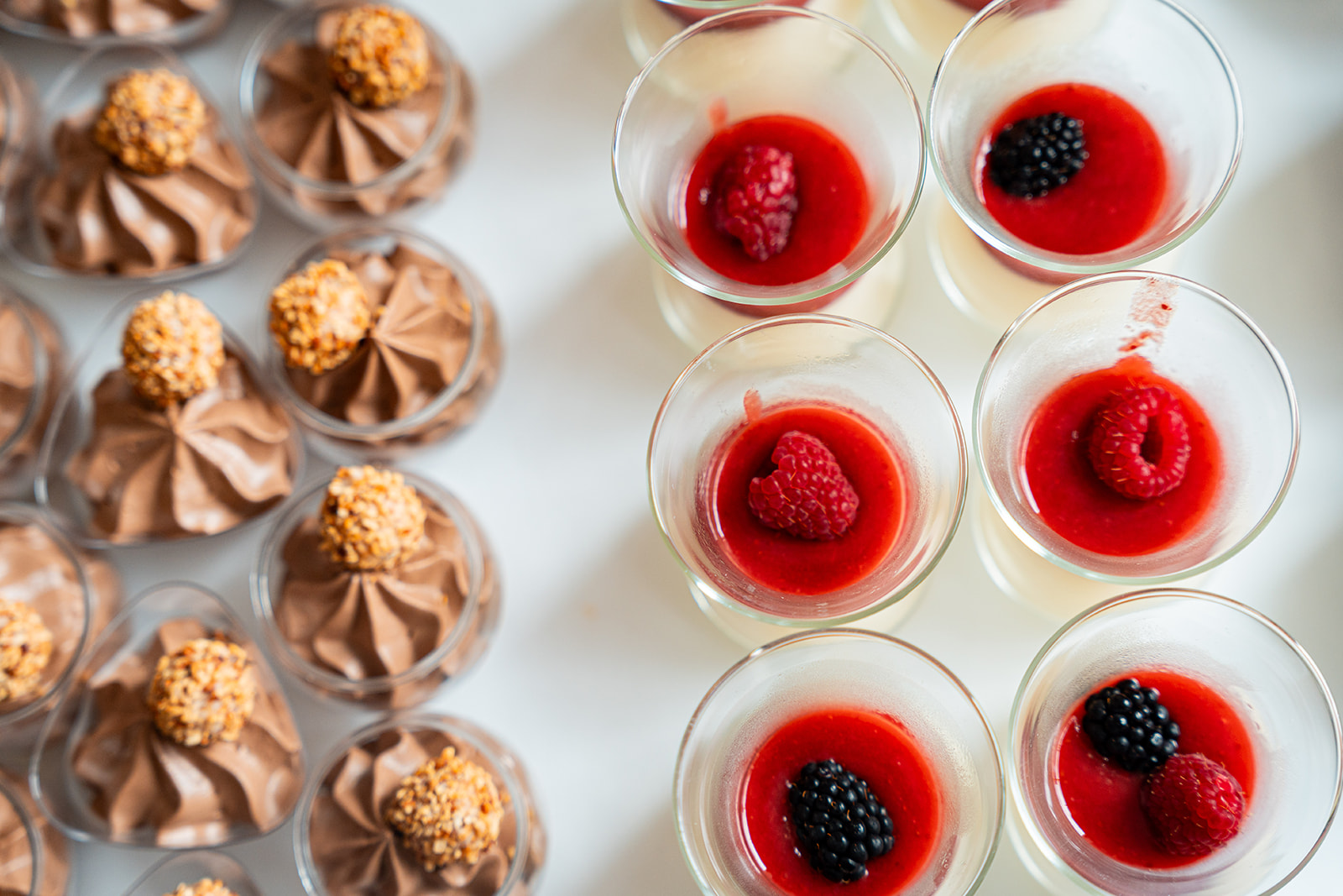 Detail van panna cotta met frambozen en bramen naast chocolademousse