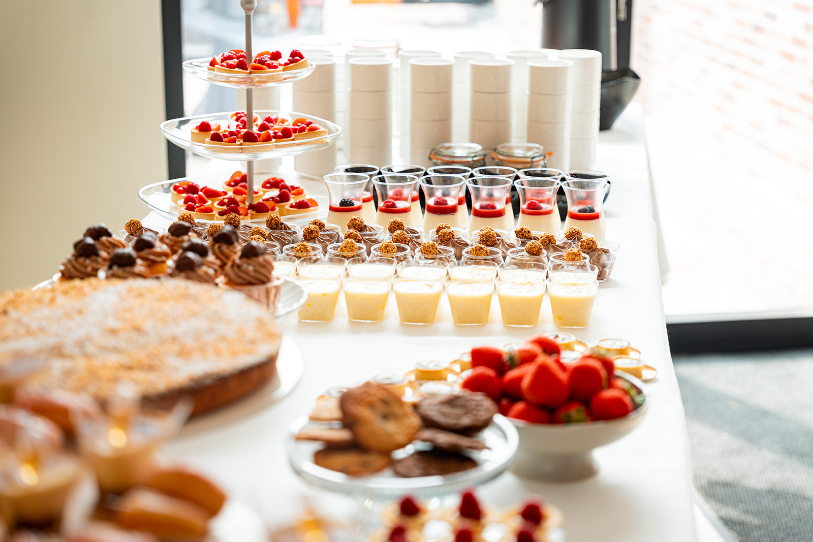 Etagère met fruittaartjes en assortiment desserts in glaasjes