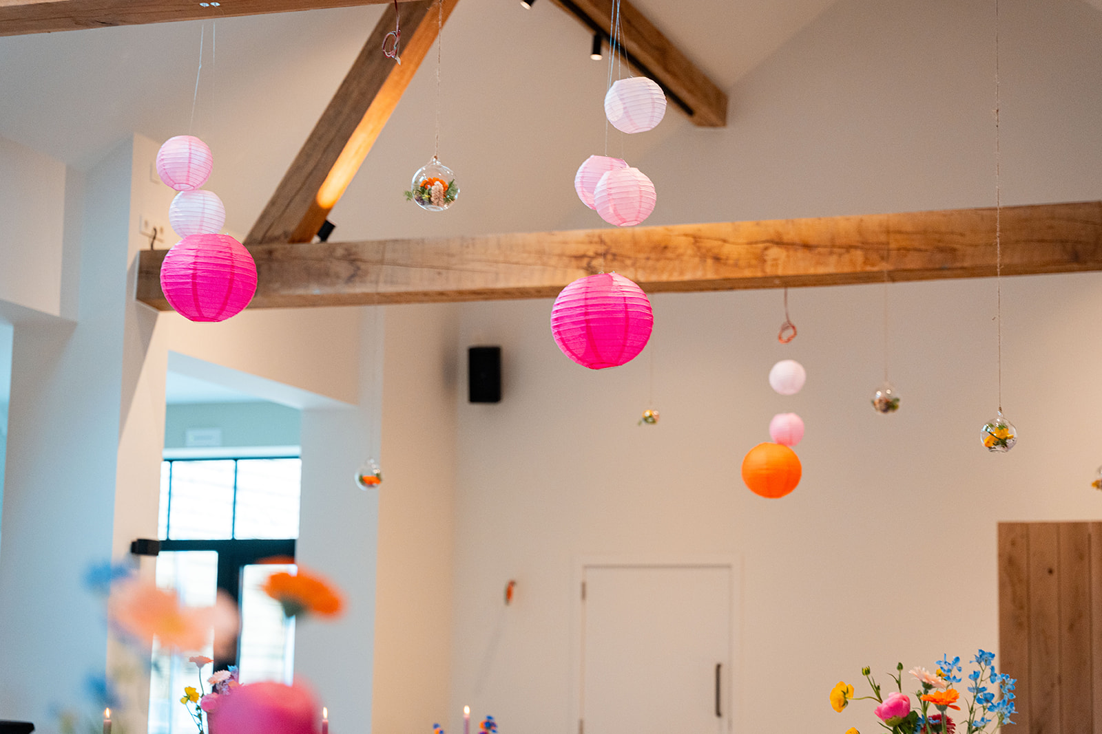 Roze en oranje lampionnen onder authentieke houten balken