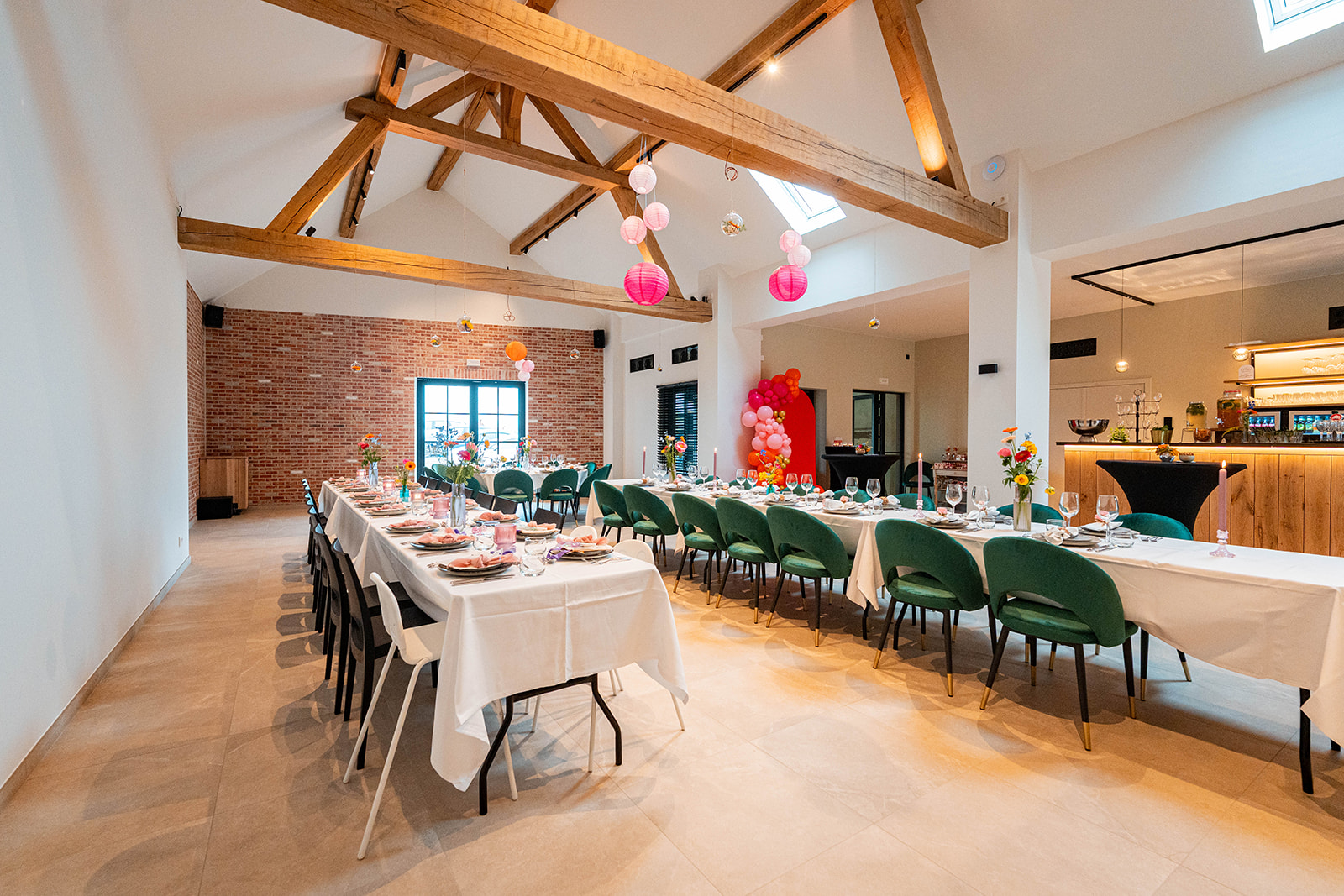 Volledig gedekte feestzaal met bakstenen muur en kleurrijke decoratie